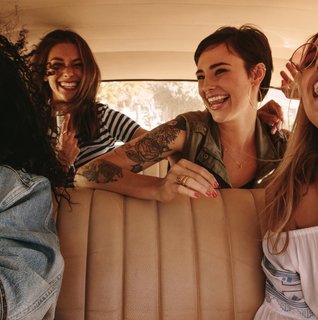 Friends laughing together on a bachelorette road trip in Central Pennsylvania, representing a fun and easy day-trip getaway for a modern bride.