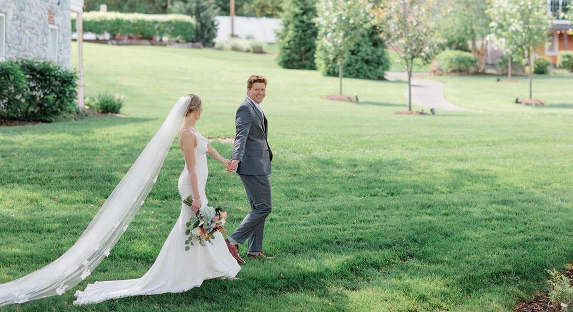 wedding couple smiling at each other and holding hands